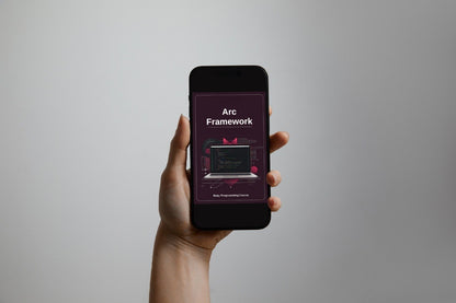 Hand holding a smartphone displaying 'Arc Framework' on a gray background